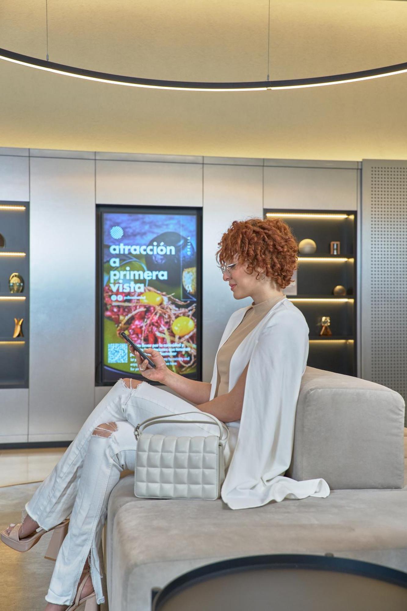 Pullman Santiago Vitacura ภายนอก รูปภาพ A woman using a mobile phone to interact with a digital signage display